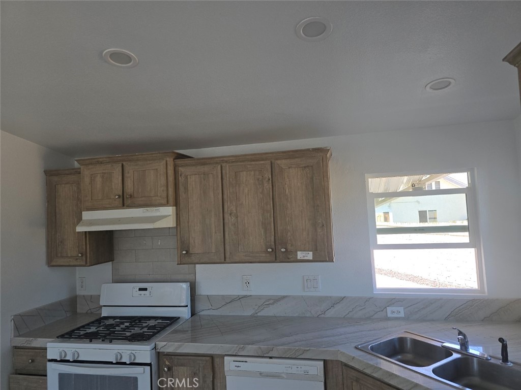 13096 Blackbird Street, Unit 164 Garden Grove, CA 92843 - Photo 7 of 19 a kitchen with granite countertop a sink a stove and cabinets
