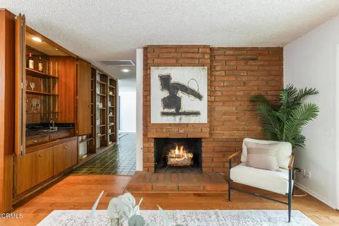 a living room with furniture mirror and a fireplace