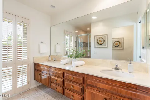a bathroom with a granite countertop double vanity sink and a mirror
