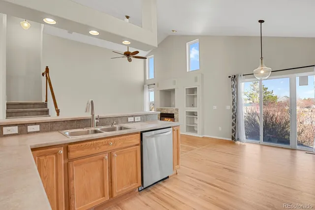 a kitchen with stainless steel appliances granite countertop a sink a stove and a wooden floor