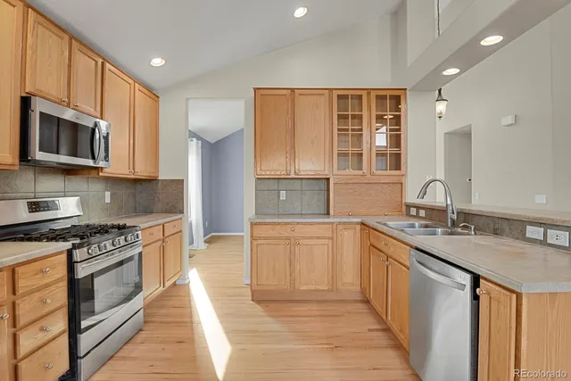 a kitchen with stainless steel appliances granite countertop a stove sink microwave and cabinets