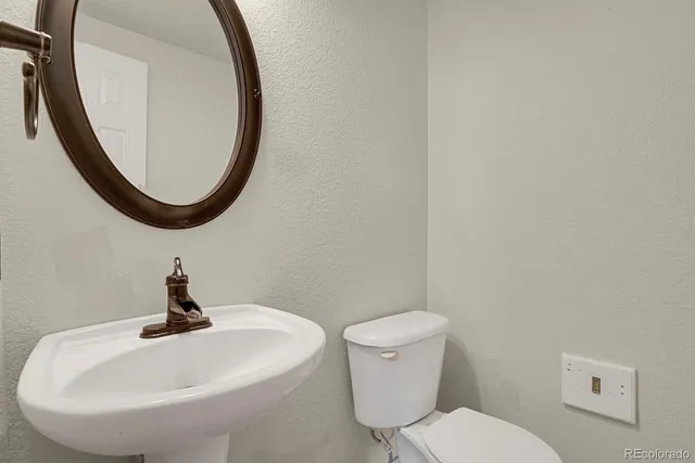 a bathroom with a toilet a sink and a mirror