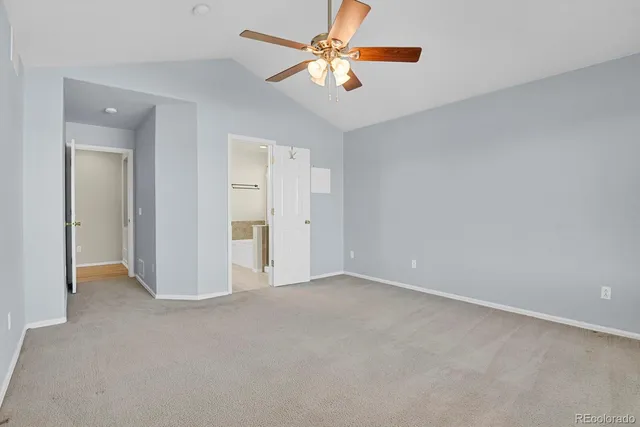 an empty room with closet and a ceiling fan