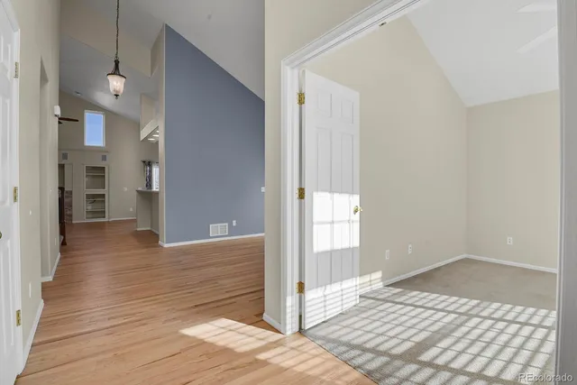 a view of a hallway with wooden floor and a living room