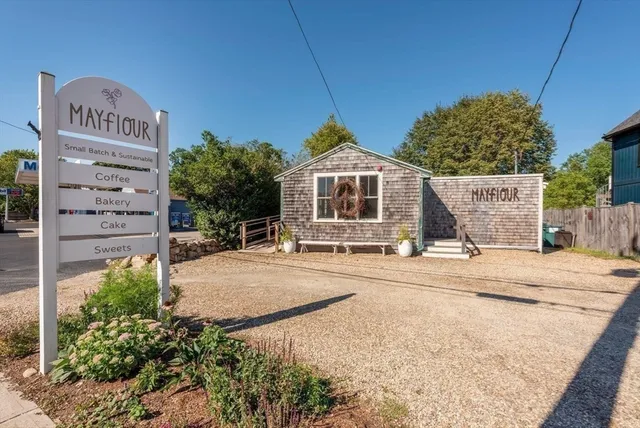 a living room with stainless steel appliances kitchen island granite countertop furniture and a dining table with wooden floor