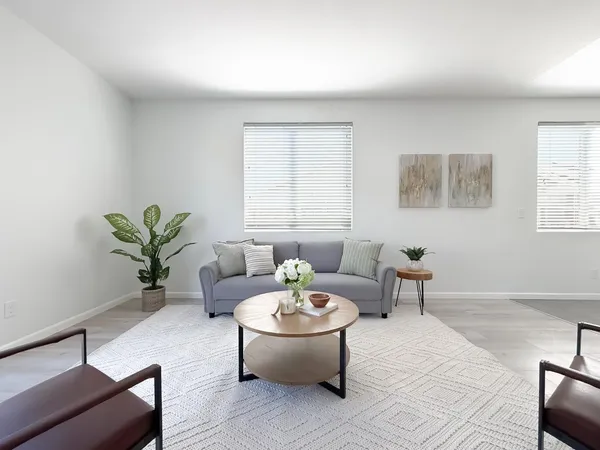 a living room with furniture and a dining table with kitchen view