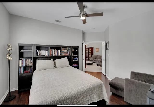 a bedroom with a large bed and a book shelf