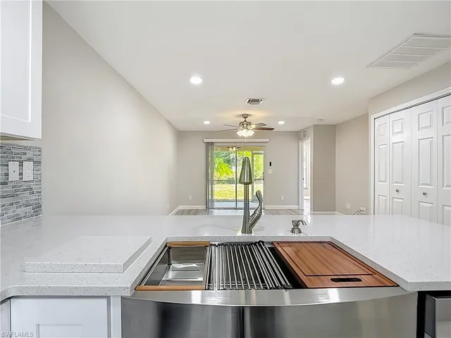 a view of kitchen with a sink and dishwasher with wooden floor