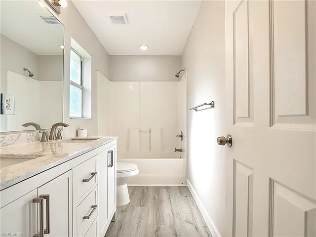 a bathroom with a sink a toilet and a large mirror