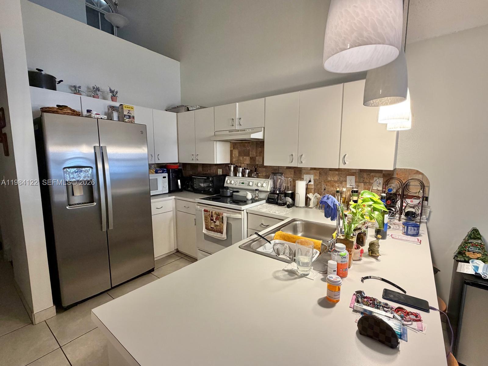 3858 Southwest 153rd Place Miami, FL 33185 - Photo 13 of 37 a kitchen with stainless steel appliances a sink a refrigerator and a stove top oven
