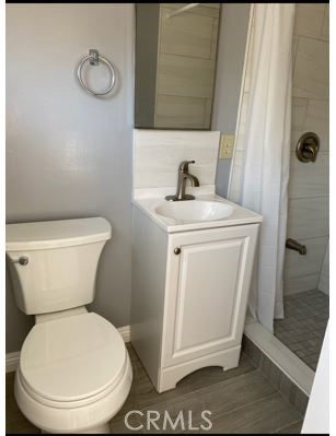 9206 Rendalia Street Bellflower, CA 90706 - Photo 25 of 27 a white toilet sitting next to a bathroom sink