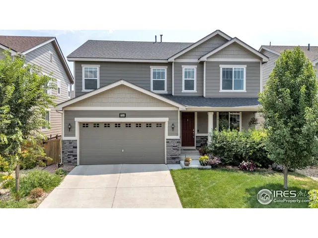 a front view of a house with a garden and garage
