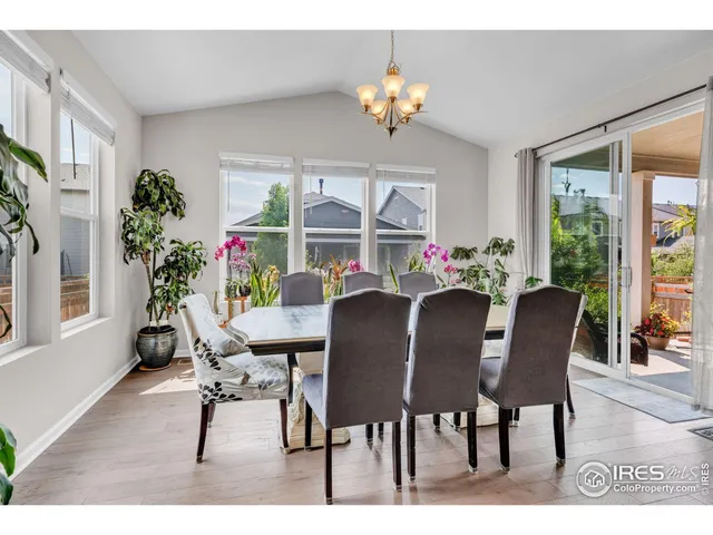 a dining room with furniture a large window and a chandelier
