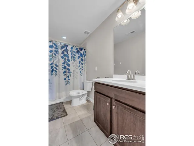 a bathroom with a sink a toilet and shower curtain