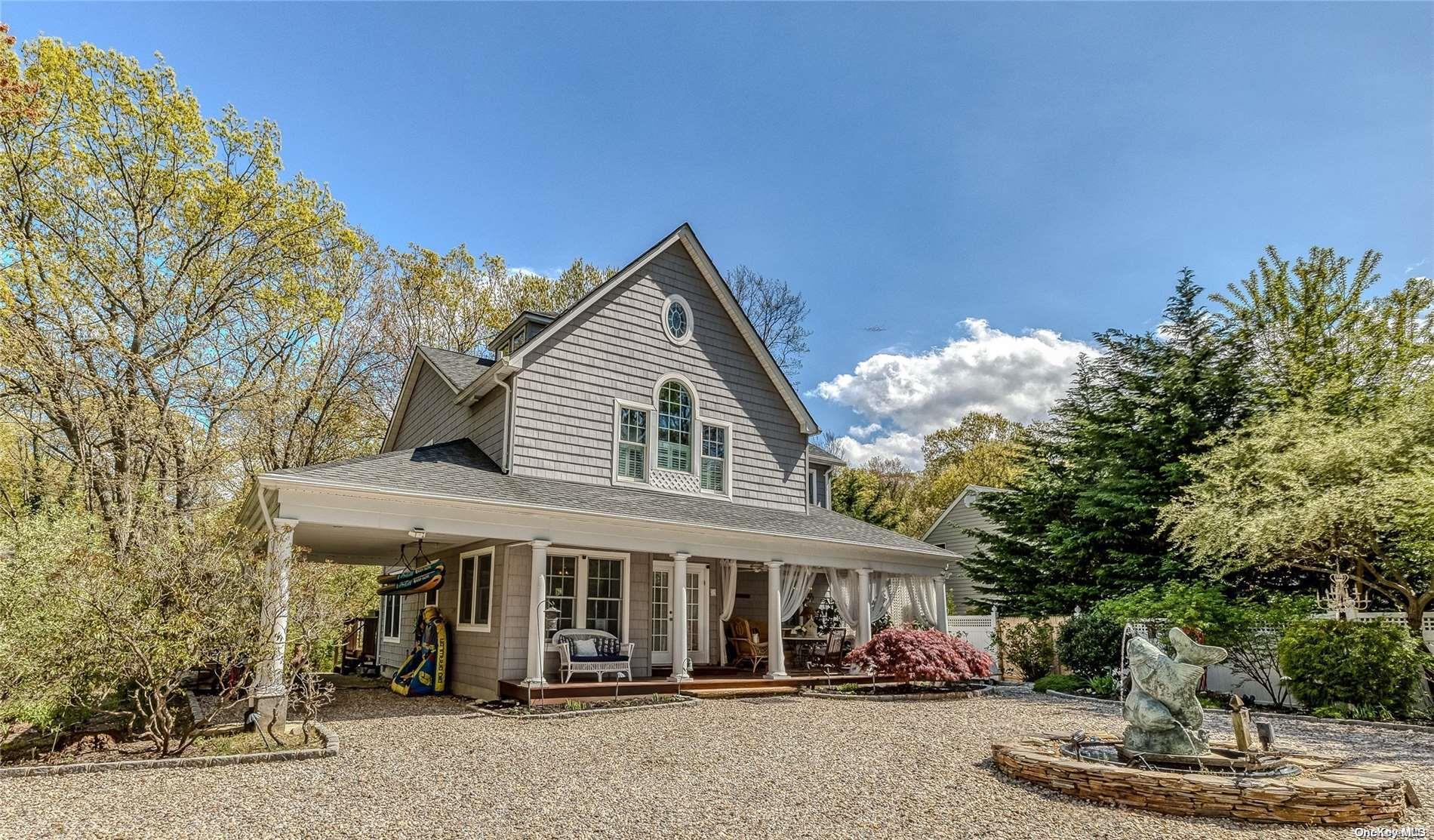 a view of a white house with large windows and plants