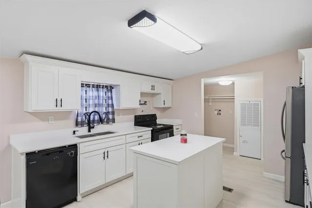a kitchen with a sink a refrigerator and cabinets