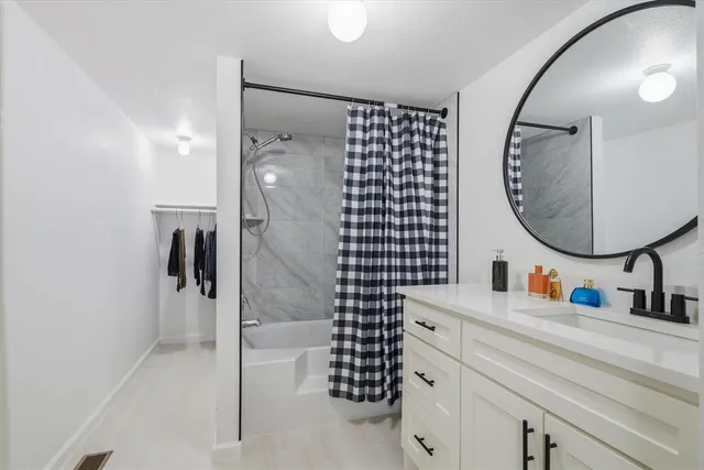 a bathroom with a sink mirror and shower