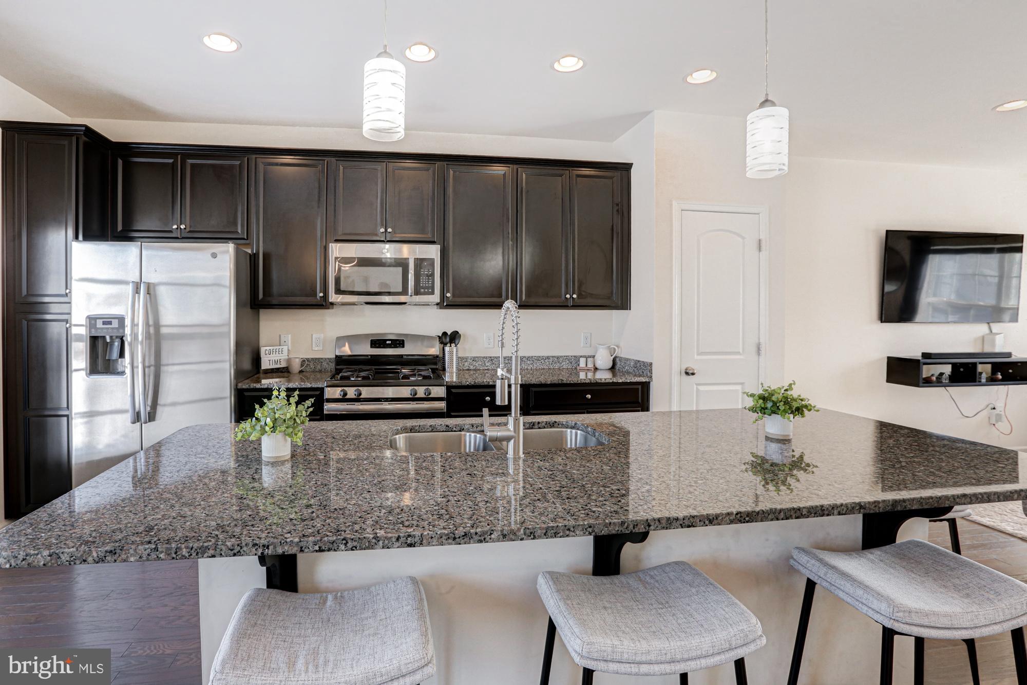 1102 Wickersham Way Middletown, DE 19709 - Photo 34 of 68 a kitchen with stainless steel appliances granite countertop a sink refrigerator and chairs