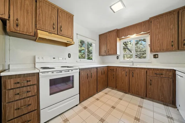 a kitchen with stainless steel appliances granite countertop a refrigerator and a stove top oven