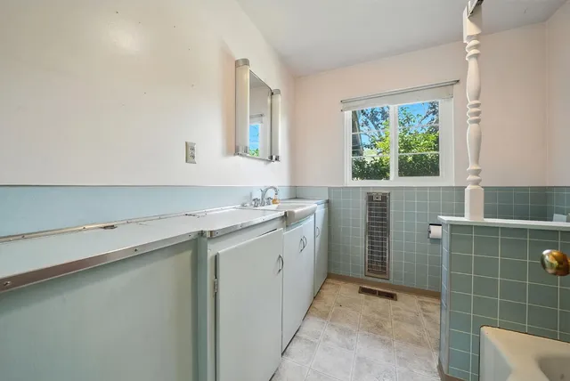 a room with a sink cabinets and window