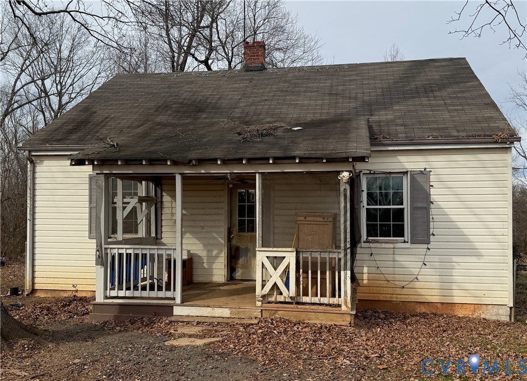 Front view of property with a shingled roof, a chi