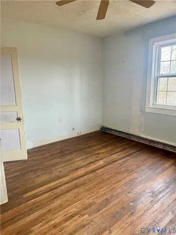 an empty room with wooden floor and a window