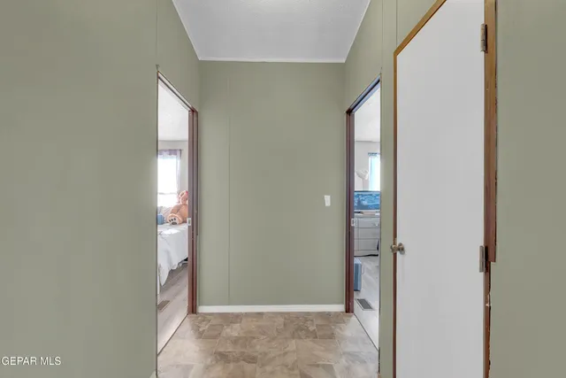 a bedroom with a bed a chair and potted plant on the dresser