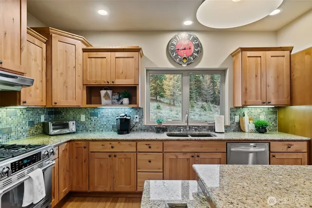 a kitchen with stainless steel appliances granite countertop a stove a sink and a granite counter tops