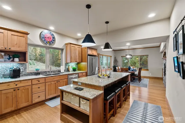 a large kitchen with stainless steel appliances granite countertop a large center island and a stove
