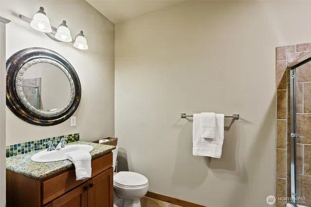 a bathroom with a granite countertop toilet a sink and a mirror