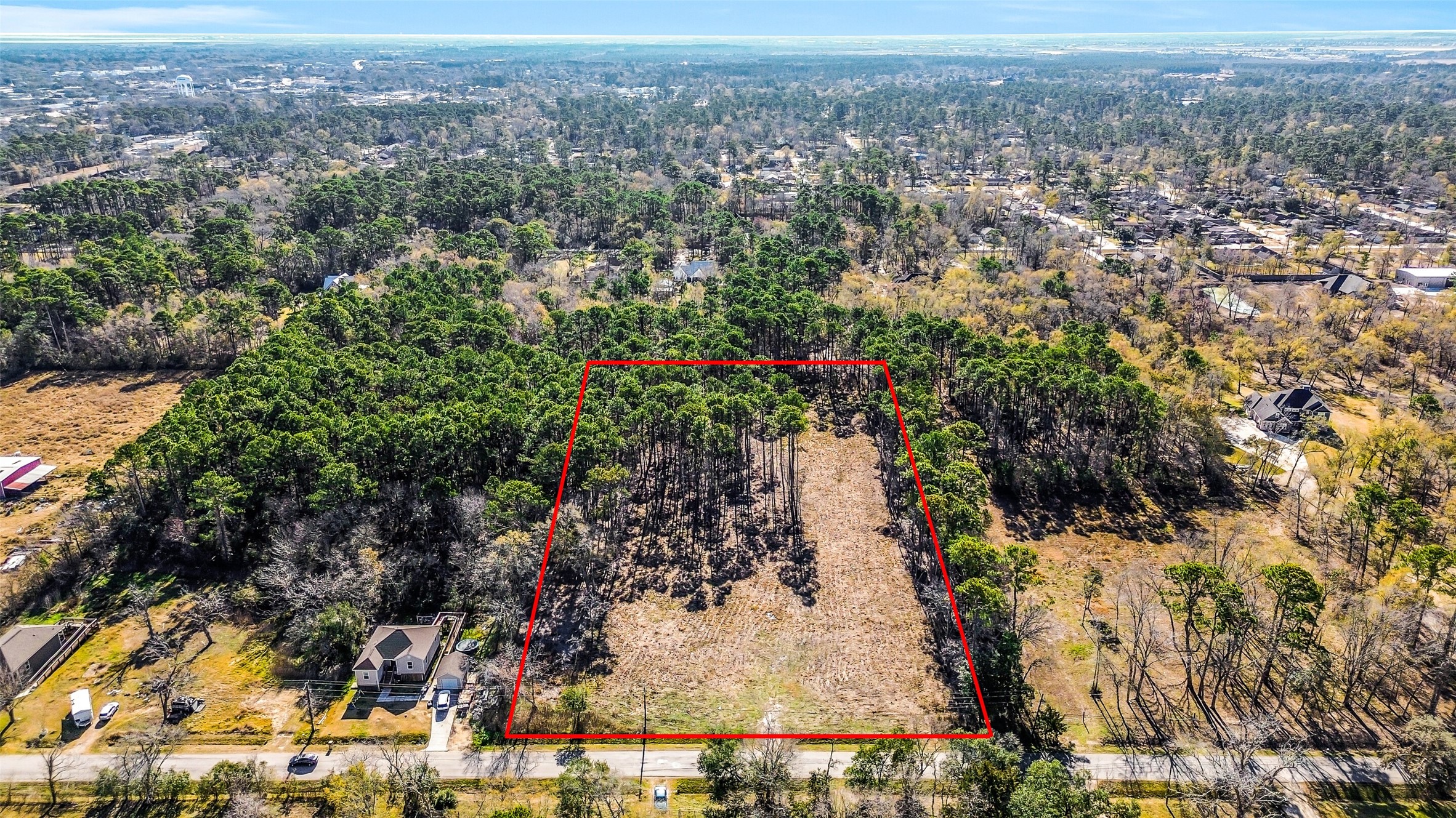 an aerial view of residential houses with outdoor space and trees