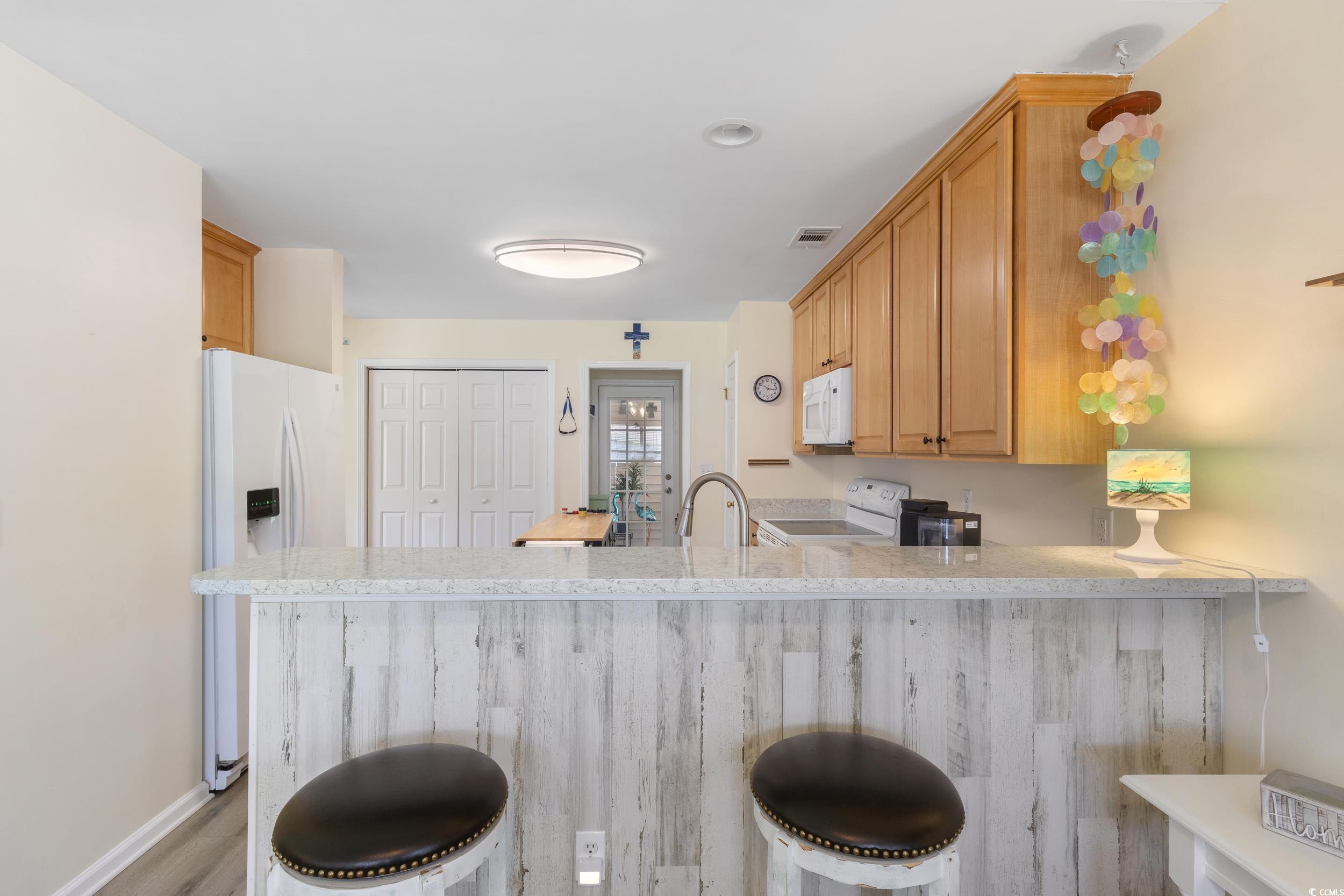 283 Whitchurch Street Murrells Inlet, SC 29576 - Photo 16 of 40 Kitchen with white appliances, a peninsula, a brea