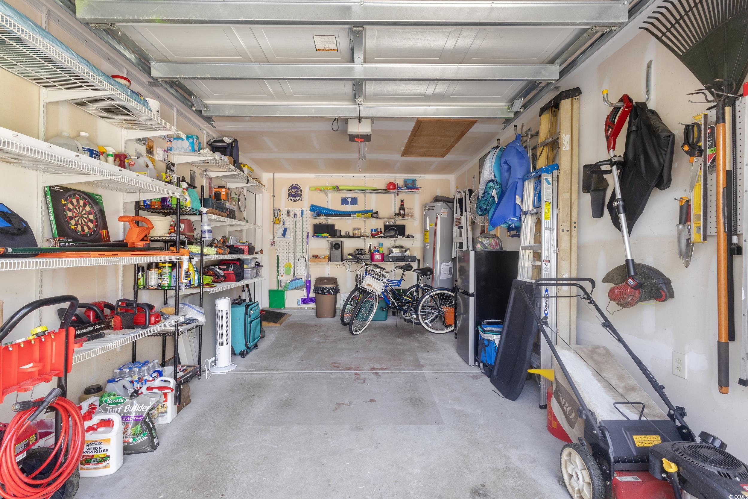 283 Whitchurch Street Murrells Inlet, SC 29576 - Photo 19 of 40 Garage with water heater, a garage door opener, an