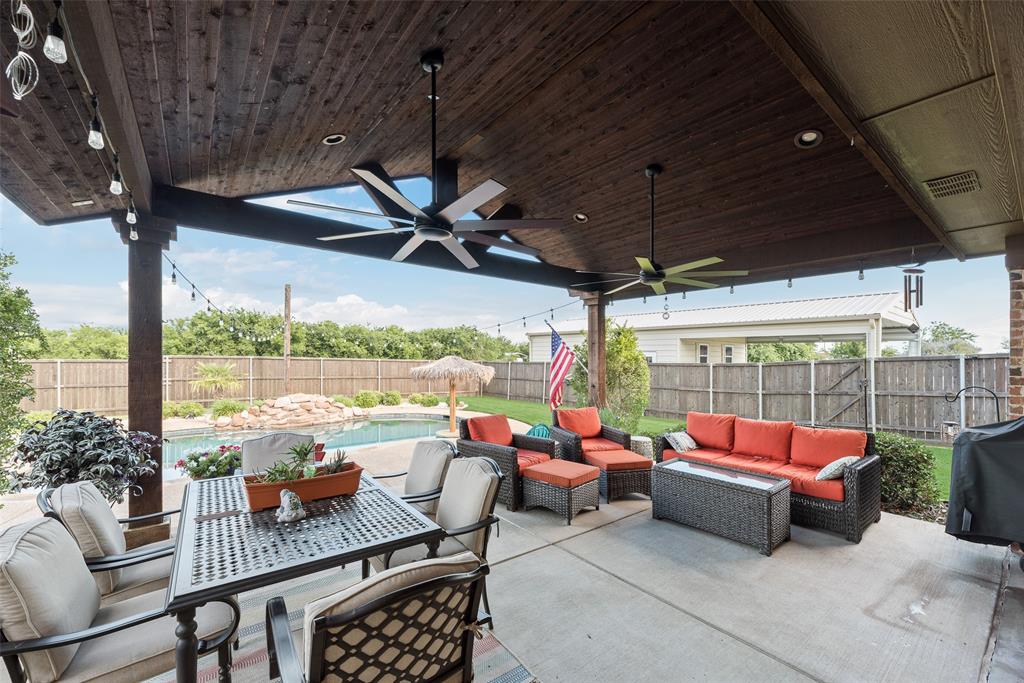 1132 Chartres Street Kaufman, TX 75142 - Photo 19 of 25 Expansive covered patio featuring a dark wood-finish ceiling, multiple ceiling fans, recessed lighting, and string lighting