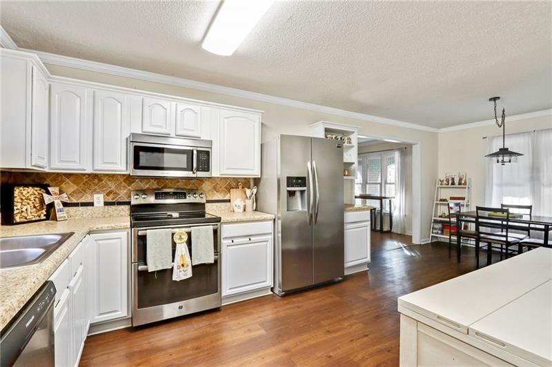 228 Shady Lane Canton, GA 30115 - Photo 16 of 36 a kitchen with stainless steel appliances a stove a sink a refrigerator white cabinets and wooden floor