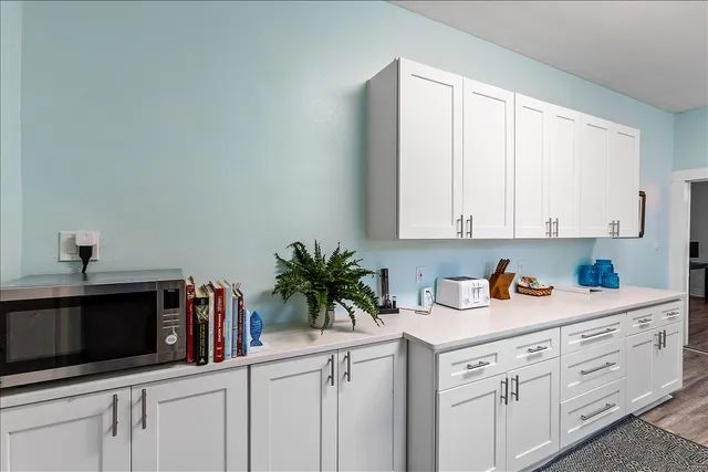 a kitchen with white cabinets and white appliances