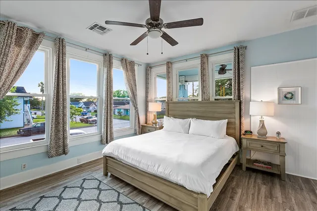 a bedroom with a large bed and a chandelier fan