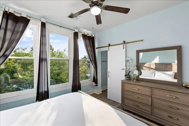 a bedroom with a bed and a large window