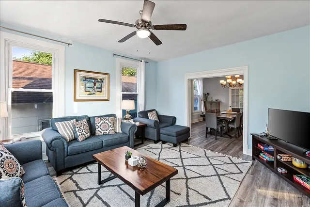 a living room with furniture a flat screen tv and a window