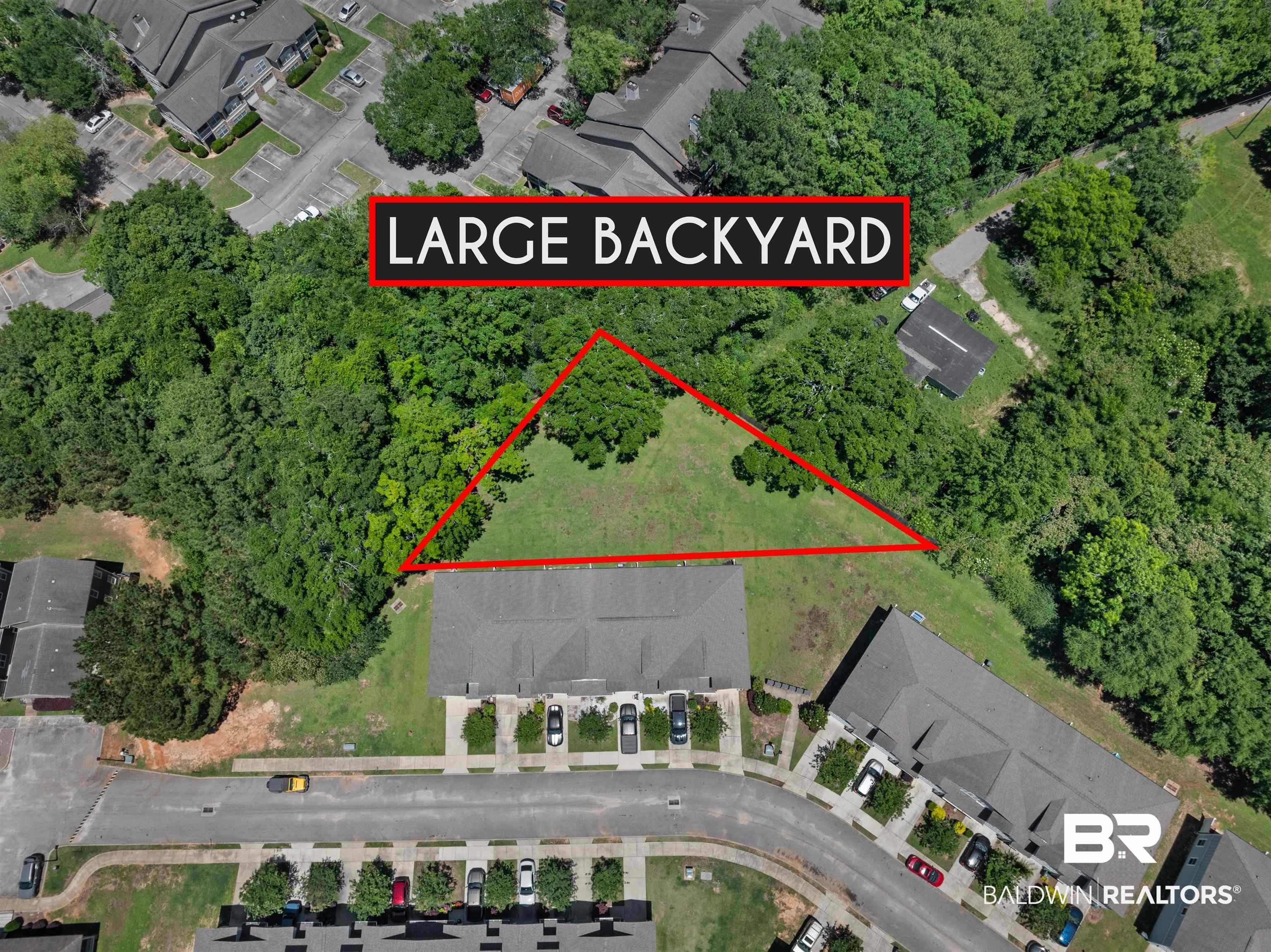 25806 Pollard Road, Unit 6 Daphne, AL 36526 - Photo 35 of 38 Expansive green space featuring mature trees and a clear, flat area for outdoor activities