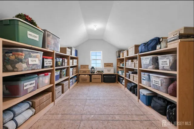 a view of an empty room with furniture and window