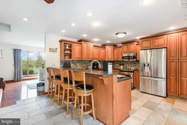 a kitchen with stainless steel appliances granite countertop a refrigerator and a stove top oven