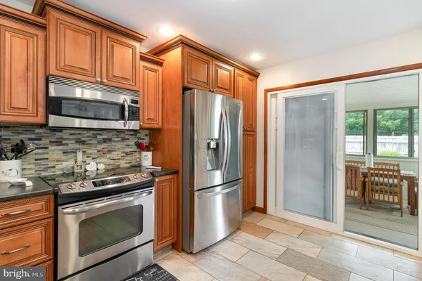 a kitchen with stainless steel appliances granite countertop a refrigerator stove and sink