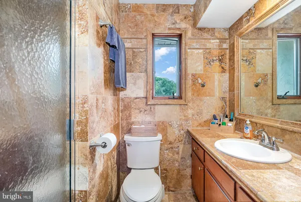 a bathroom with a granite countertop toilet sink and a mirror