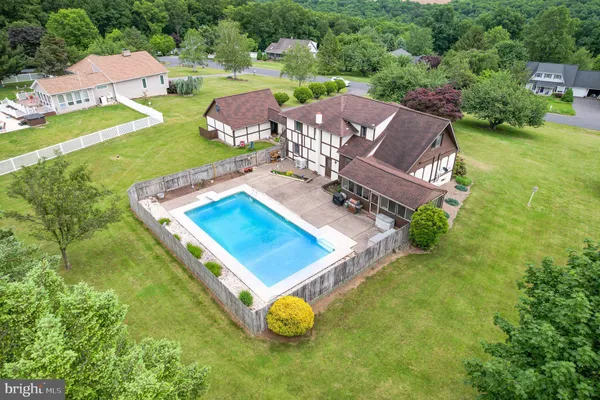an aerial view of a house with a garden and swimming pool