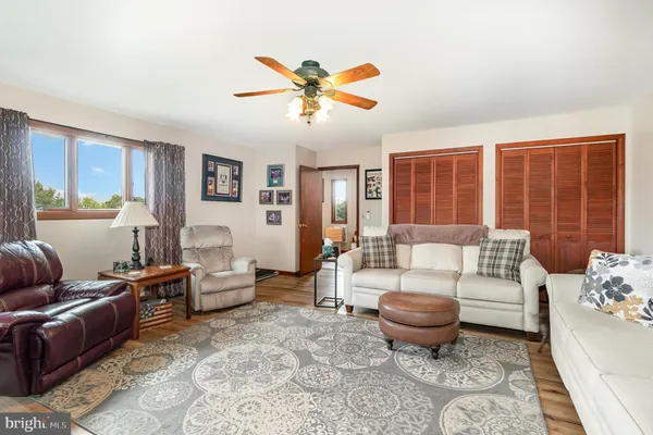 a living room with furniture ceiling fan and a window