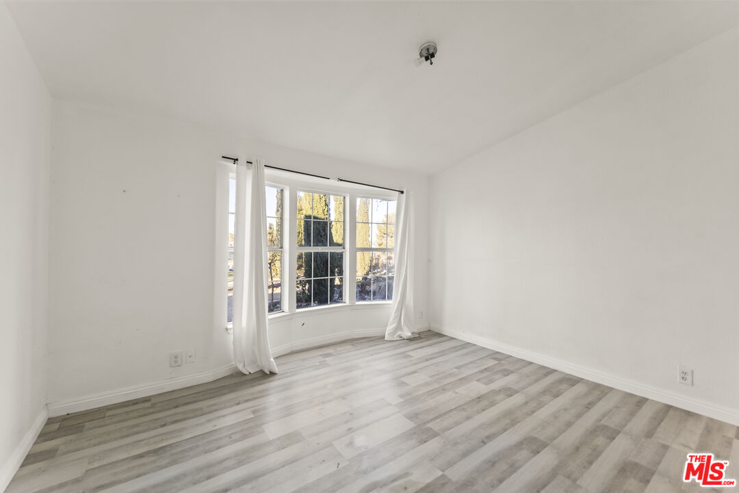 6677 Maricopa Road Phelan, CA 92371 - Photo 16 of 38 an empty room with wooden floor and windows