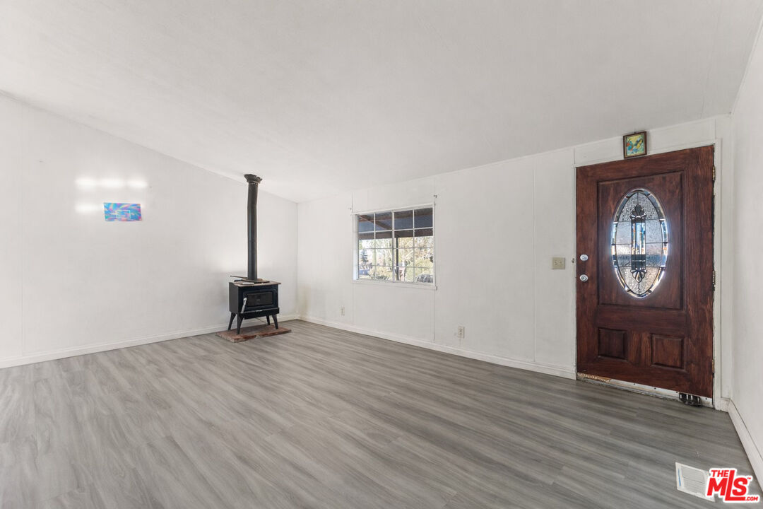 6677 Maricopa Road Phelan, CA 92371 - Photo 21 of 38 a view of an empty room with a window and wooden floor