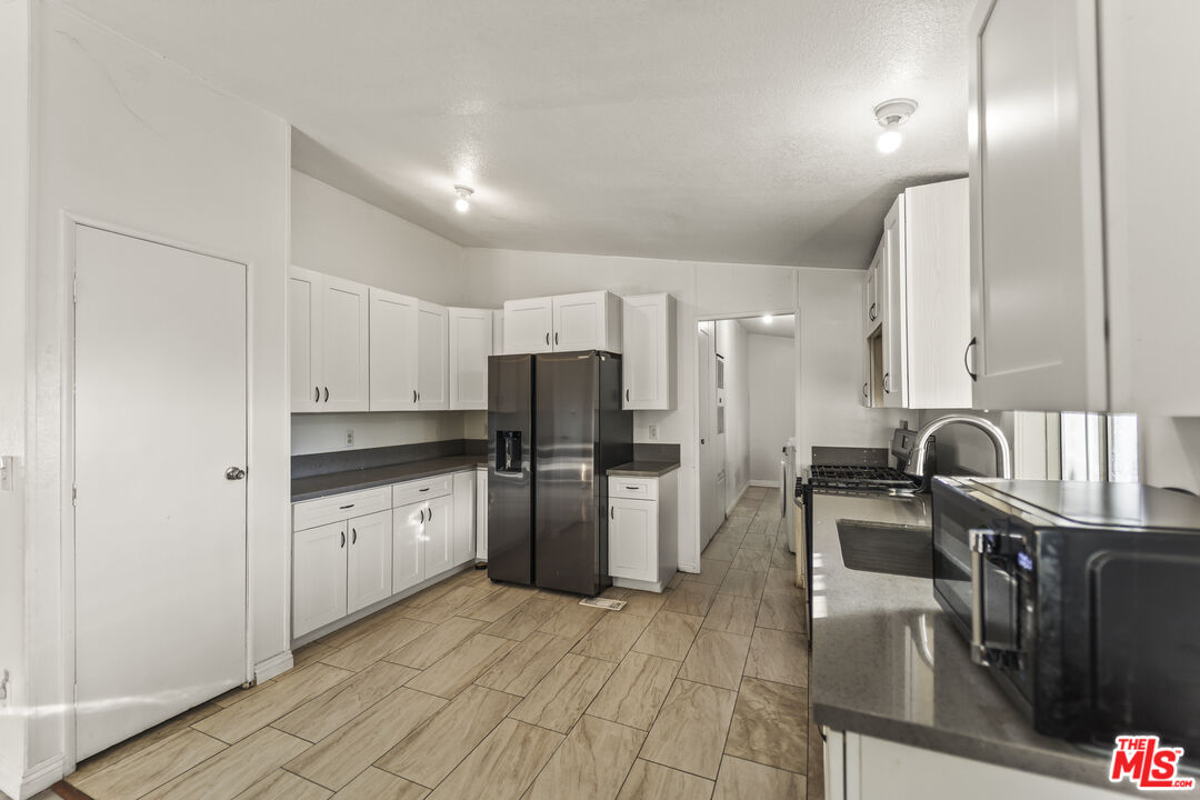 6677 Maricopa Road Phelan, CA 92371 - Photo 24 of 38 a kitchen with stainless steel appliances granite countertop a sink refrigerator and cabinets