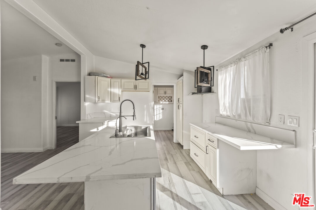 6677 Maricopa Road Phelan, CA 92371 - Photo 3 of 38 a large white kitchen with cabinets